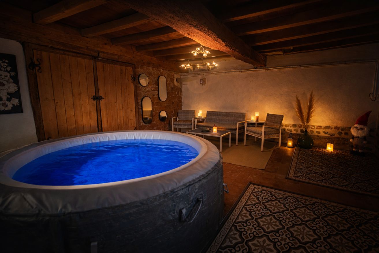 Jacuzzi intérieur poutres et bougies – Espace spa privatif Les Pétillières