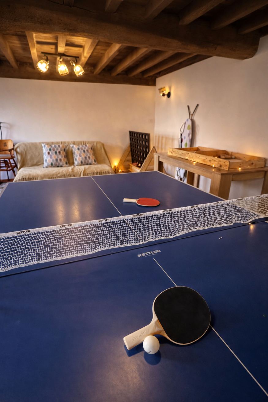 Salle de jeux ping-pong sous poutres – Gîte Les Pétillières